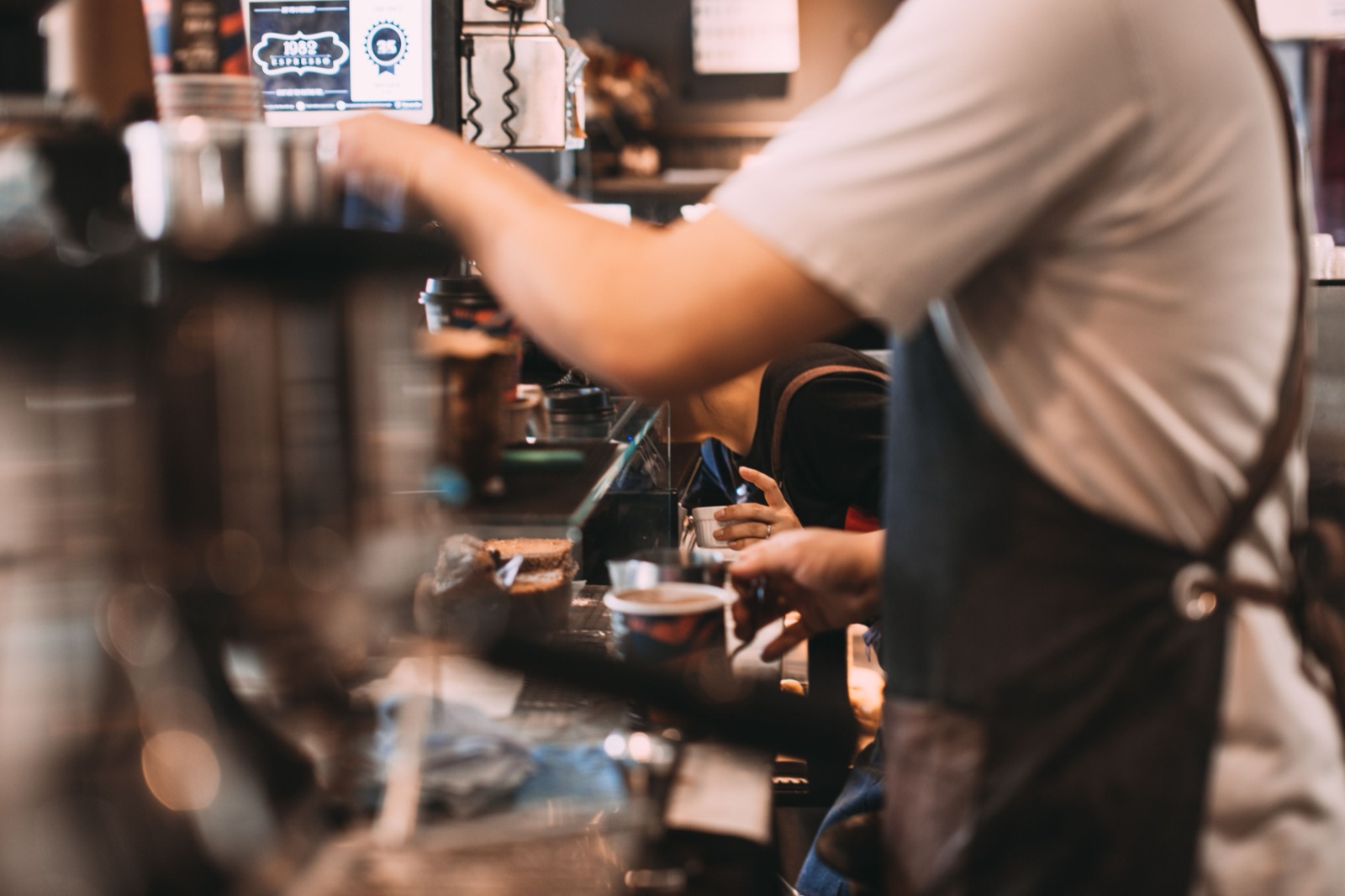 Baristas serving customers at the ground-floor cafe inside NODE Miami, where retail and public space keep the building open to the neighborhood